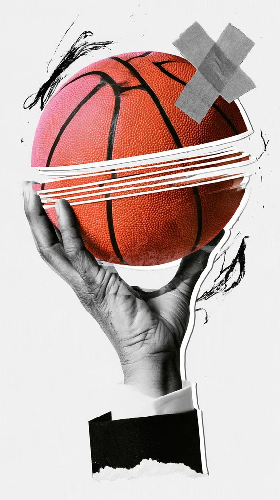 Grayscale hand in a suit sleeve holding a sliced orange basketball with a taped X and scribbles