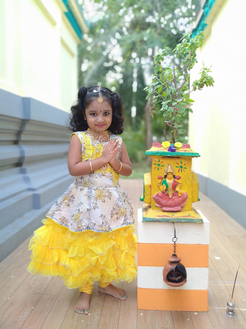 Little Girl in Traditional Indian Dress with Decorative Idol