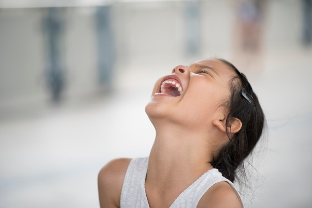 Adorable little girl laughing in the street