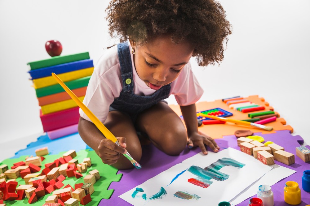 Kid drawing on play mat in studio 
