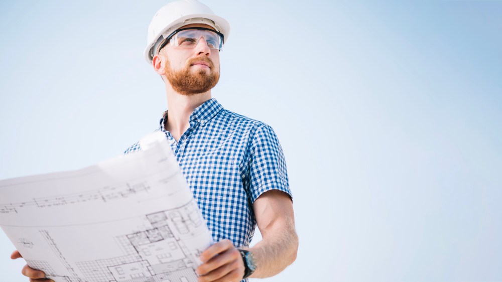 Man with blueprint looking away