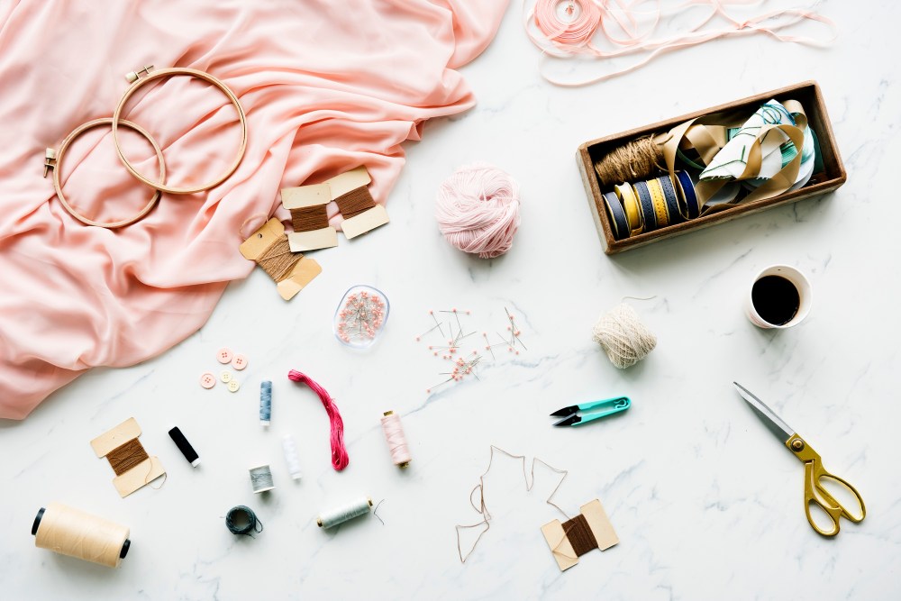 Needle sewing handmade objects on marble table