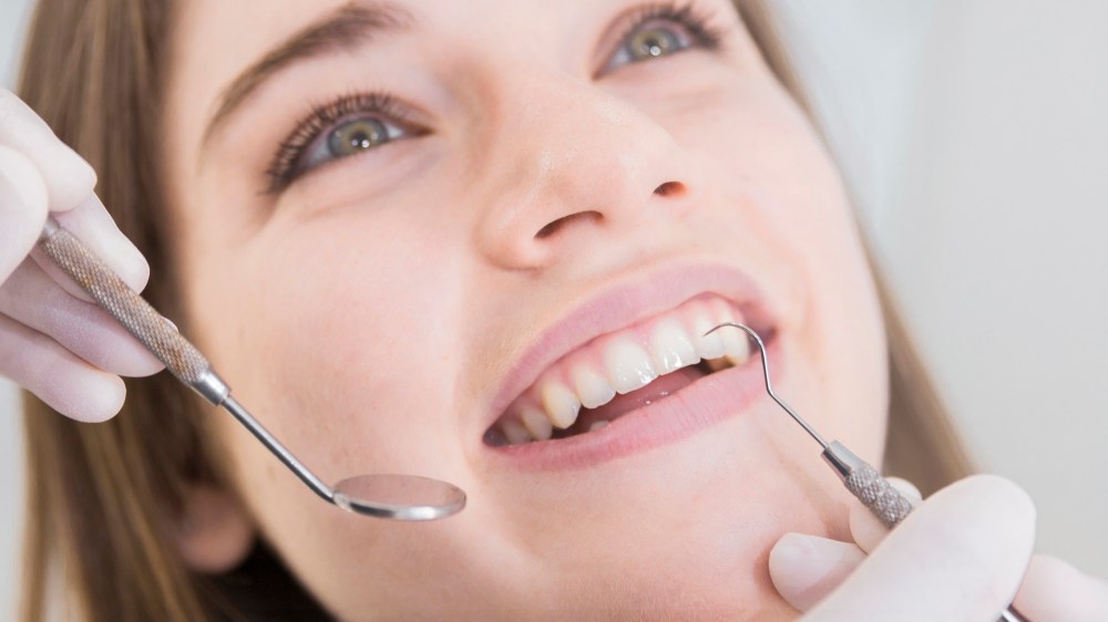 Woman having teeth examined at dentists