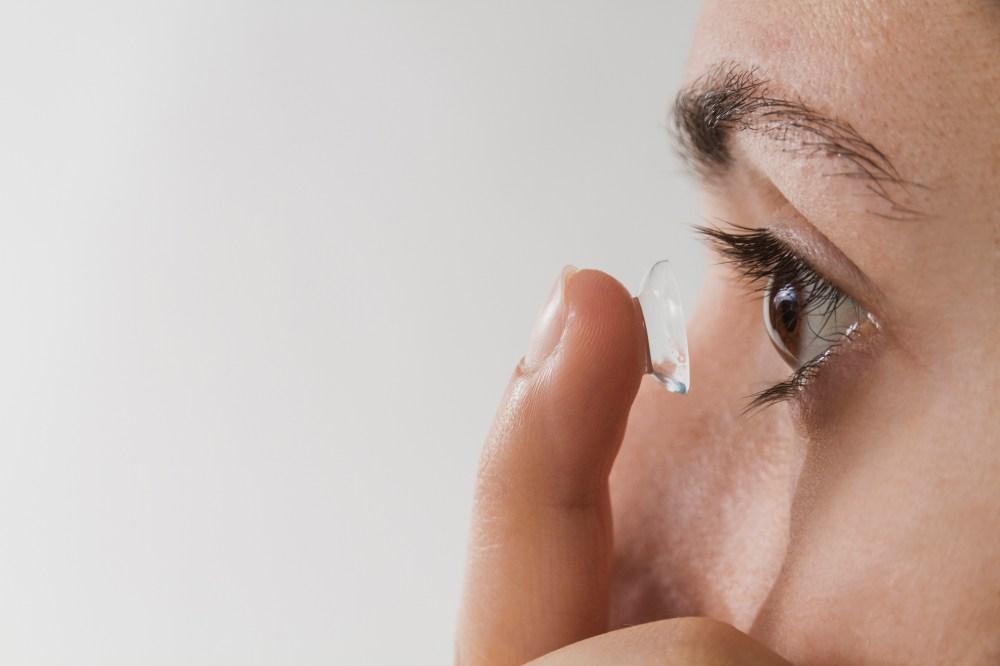 Woman putting contact lens in eye