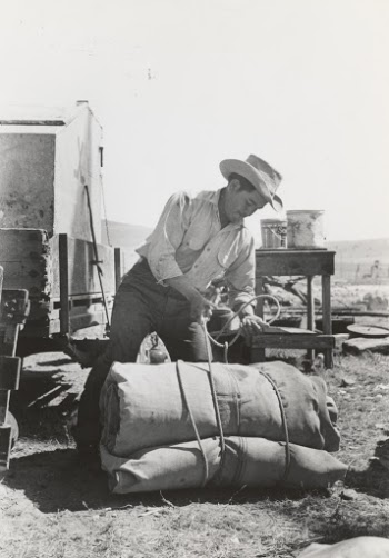1939. 
Cowboy tying up bedroll. Cattle ranch near Marfa, Texas.
Photographer Lee Russell