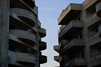 2 Brown High Rise Building Facing Each Other at Daytime
