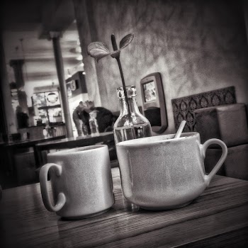 2 Ceramic Mugs Near Clear Glass Flower Vase on Table in a Room