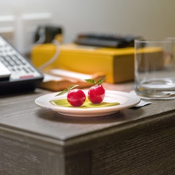 2 Cherry Fruits on Round White Ceramic Saucer