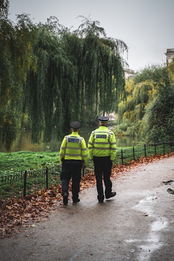 2 Securities Walking Beside Dried Leaves