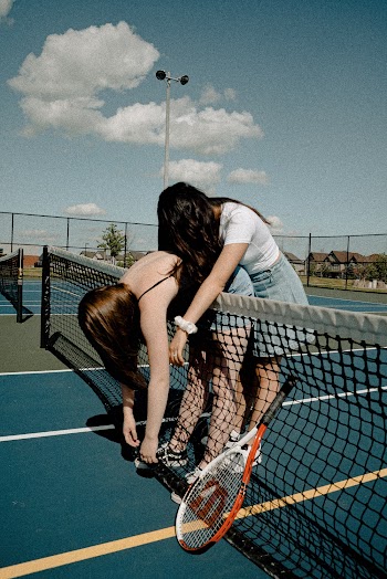 2 Women Besides Tennis Net