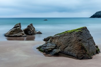 3 Brown Boulders on Seashore during Daytime