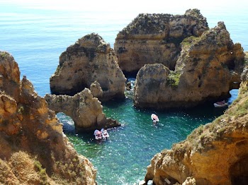 3 White Boats Near a Rock Formation