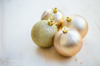 4 Christmas Baubles on Beige Wooden Flooring