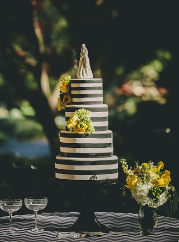 4-tier Cake next to glassware and a flower vase