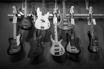8 Electric Guitars Hanged on Brown Steel Bar