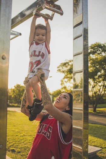 A Baby and a Woman Wearing Chicago Bulls Jersey