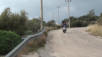 A bike passes and then a Mother with child in sling walks away ...