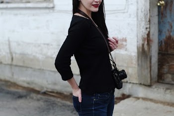 A Black Camera Sling On A Woman's Neck