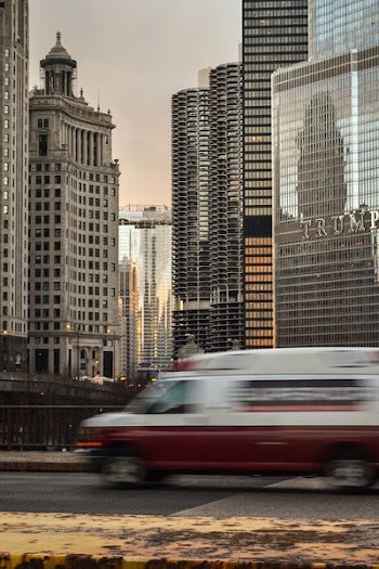 A blurry car on a bridge in a city with skyscrapers at the back