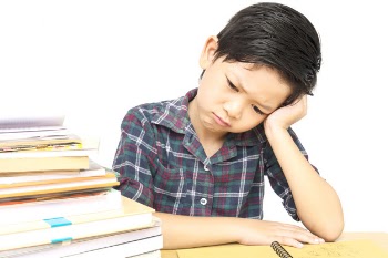 A boy is unhappy doing homework
