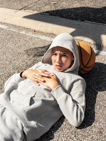 A Boy Luying On The Floor With Basket Ball as Pillow