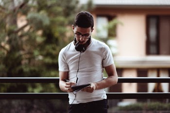 A boy with headphones on the neck writing something on his notepad with a pen, outside in the nature.
Thinking about the life and sharing his toughs with the world.
Some autumn feelings are around
The light comes behind him