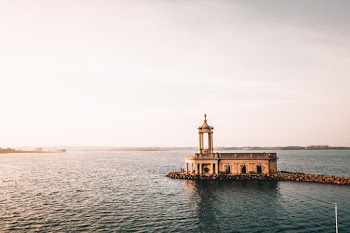 A Building With A Rooftop Balcony Built On The Breakwater