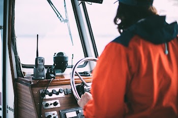 A captain steering the boat | Free Photo - rawpixel