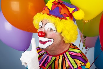 A colorful clown putting his finger to his lips so you will be quiet.