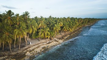 A couple walks along the coastline in the Maldives