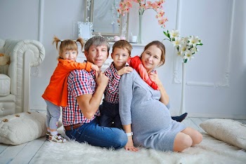 A family sitting on the floor in the living room