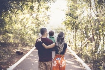 A Family Walking On The Road