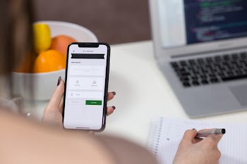 A female holding an iPhone X and taking notes 2