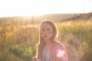 A girl in the meadow with sunflare