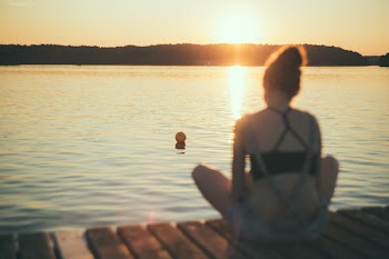 A girl sitting on a pier blurred