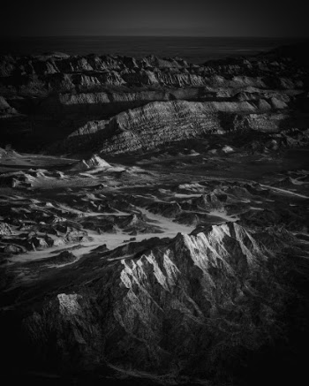 A glimmer of sunset light illuminates hills in the foreground overlooking Chile's Valle de la Luna. 