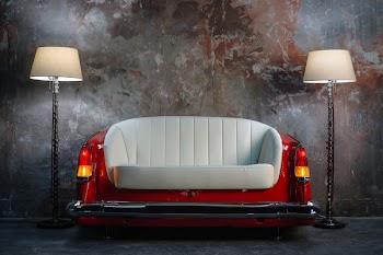 A handmade sofa and a lamp on a grunge style wall background. Made to order from the car seat.