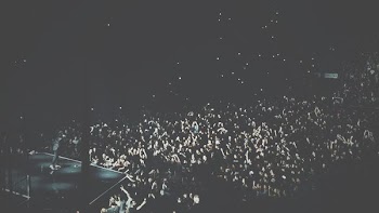 A high shot of a large crowd of people filling up a venue during a concert