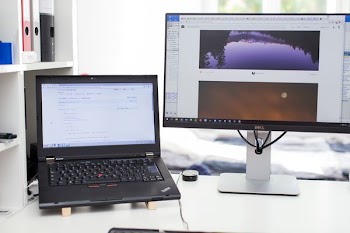 A laptop sitting next to a computer monitor.
