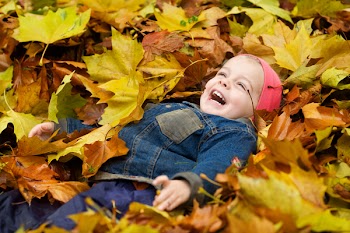 a little child playing in the leaves