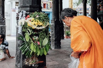 A local woman praying at an alter inside a temple.