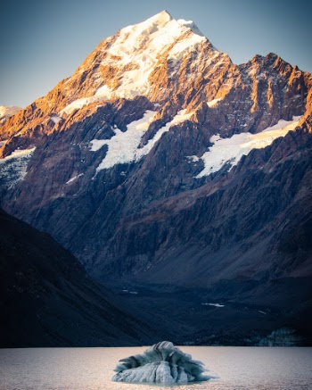A lone glacier sits beneath Mt. Cook in Hooker Lake at sunset, New Zealand. 