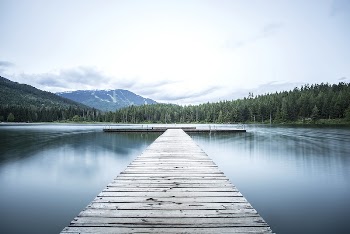 A long wooden pier on a smooth | Free Photo - rawpixel