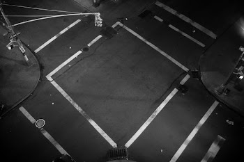 A look down at an empty intersection where traffic lines form a square