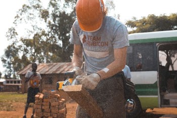 A man from a relief organization helps rebuild after a disaster in Uganda