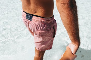 A man in shorts holding a hand