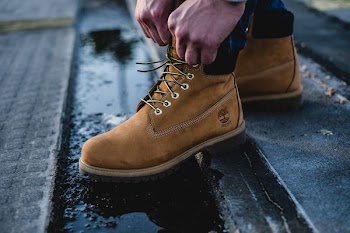A man laces up his Timberland boots
