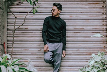 A Man Leaning On A Shutter Door