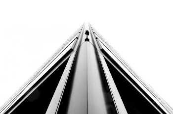 A monochrome shot of a sharp edge on a corner of a tall building