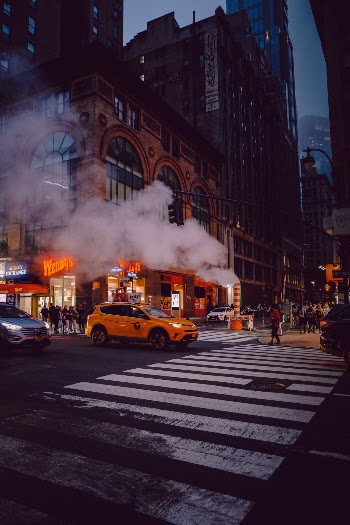A New York City taxi at a crosswalk in a foggy NYC moment.